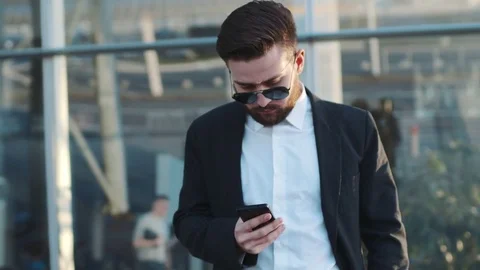 Rotation view of a young bearded man in sunglasses standing by the airport Stock Footage 74862525