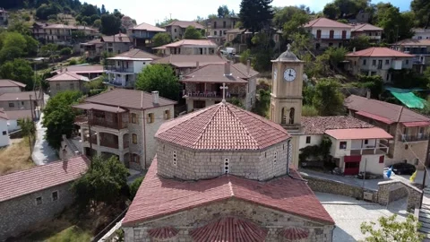 Rotational shot around old stone Orthodox Christian church with clock tower Vídeo Stock 326353603