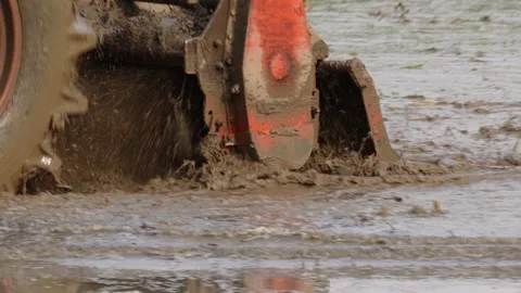 A rotavator attached with a tractor plowing in the field Stock Footage 314573385