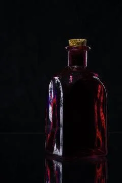 Rote Flasche auf Schwarz eckige rote Flasche mit Korken auf Glasplatte vor... Stock Photos