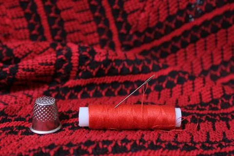 Roter und schwarzer Stoff mit Faden und Schere Red and Black Fabric With T... Stock-Fotos