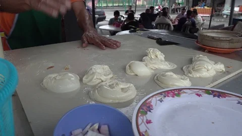Roti Canai or Paratha maker at his stall.  Stockbeeldmateriaal 77235994