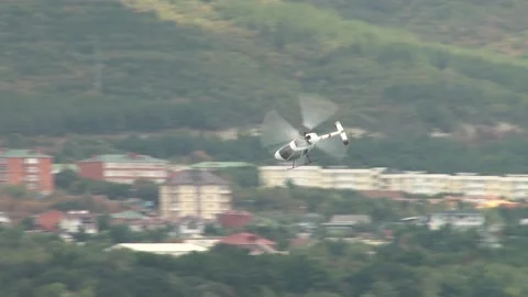 Rotorfly R-30 helicopter performs demonstration flight over waters of bay. Stock Footage 131583605