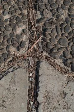 Rough Asphalt Texture And Weathered Pebble Stone Pavement With Cracks Stock Photos