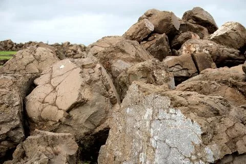 The rough boulders stacked against a brooding sky Stock Photos