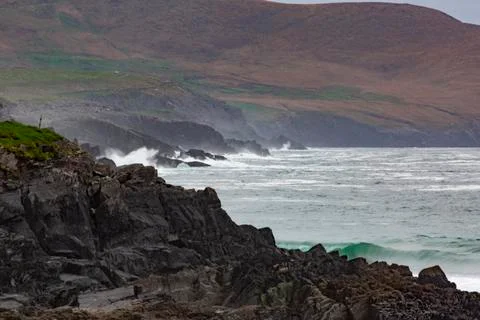 Rough breaking of waves on Irish coast line during daytime Stock-Fotos