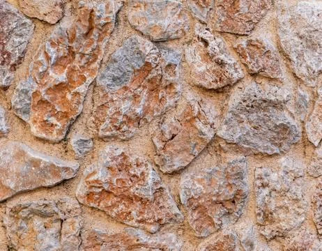 Rough brown stone wall close up, seamless textured background Foto stock