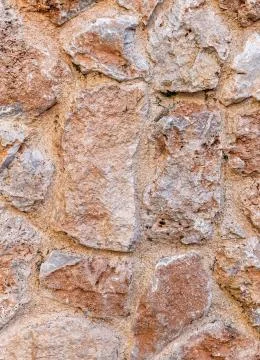 Rough brown stone wall close up, seamless textured background Foto stock