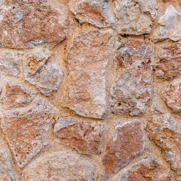 Rough brown stone wall close up, seamless textured background Foto stock