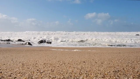 Rough, choppy waves on beach in slow motion. Gimbal shot rising slowly Stock Footage 119294938