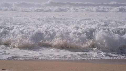Rough, choppy white waves breaking on sandy beach in spring. Close up. Stock Footage 148394070