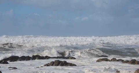 Rough, choppy white waves on the ocean in winter, splashing against rocks Video stock 119295565