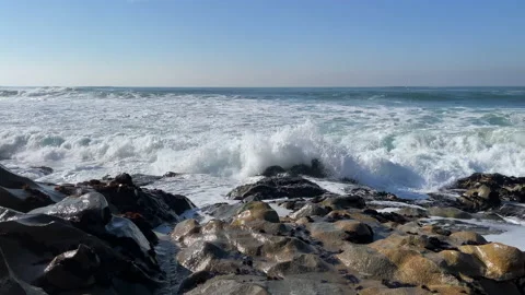 Rough, choppy white waves splashing over rocks on the beach. Slow motion Stock Footage 146674767
