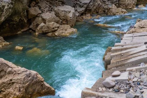 Rough clean mountain river flows along the stones. Stock Photos