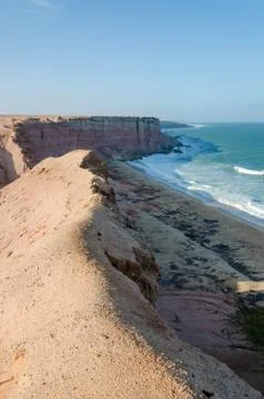 Rough coast line with towering cliffs and wild ocean in Angola Stock Photos