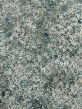 Rough concrete floor texture with embedded dark stone chips Stock Photos