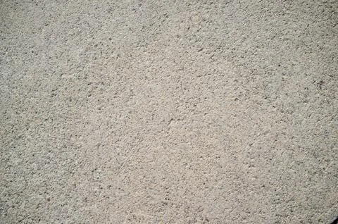 Rough concrete wall texture with small, grey rocks embedded in surface Stock Photos