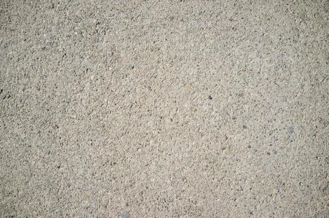 Rough concrete wall texture with small, grey rocks embedded in surface Stock Photos