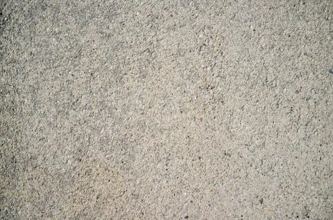 Rough concrete wall texture with small, grey rocks embedded in surface Stock Photos