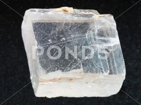 Rough crystal of Iceland spar gemstone on dark Stock Photos
