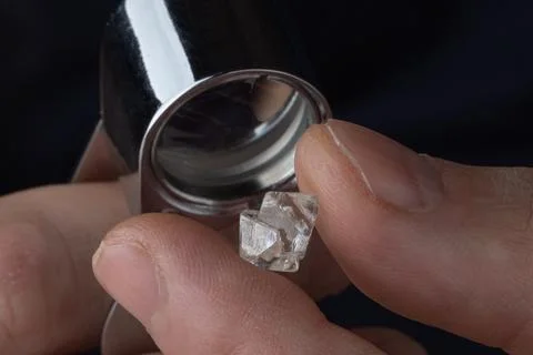 Rough diamond close up in the process of evaluation by diamond expert. Stock Photos