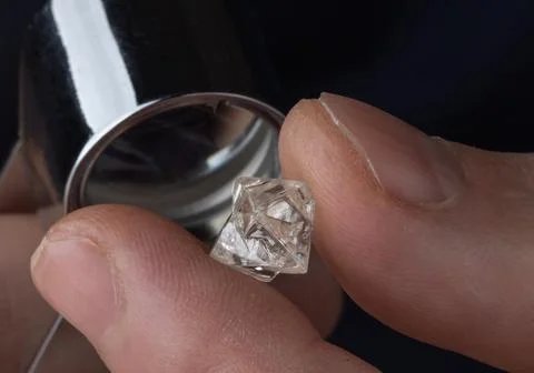 Rough diamond close up in the process of evaluation by diamond expert. Stock Photos