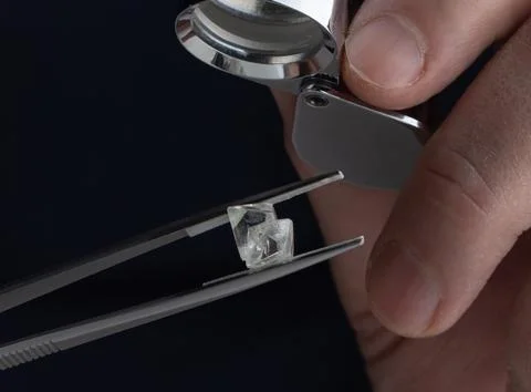 Rough diamond close up in the process of evaluation by diamond expert. Stock Photos