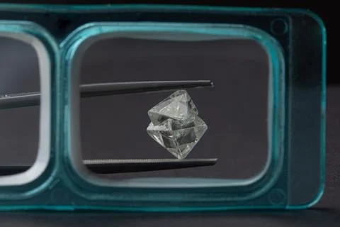 Rough diamond close up in the process of evaluation by diamond expert. Stock Photos