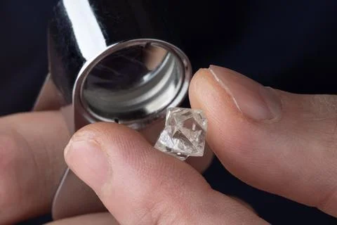 Rough diamond close up in the process of evaluation by diamond expert. Stock Photos