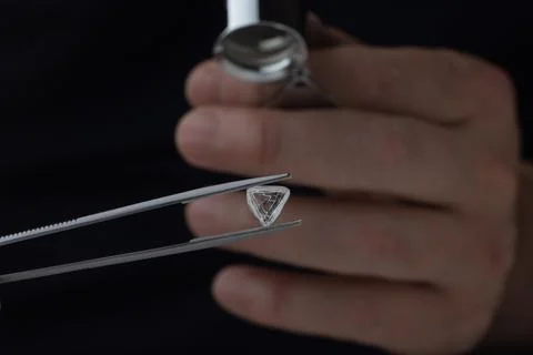 Rough diamond close up in the process of evaluation by diamond expert. Stock Photos