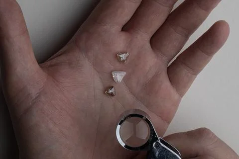 Rough diamond close up in the process of evaluation by diamond expert. Stock Photos