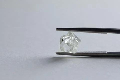 Rough diamond close up in the process of evaluation by diamond expert. Stock Photos