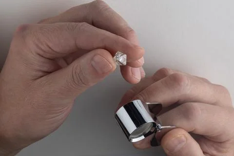 Rough diamond close up in the process of evaluation by diamond expert. Stock Photos