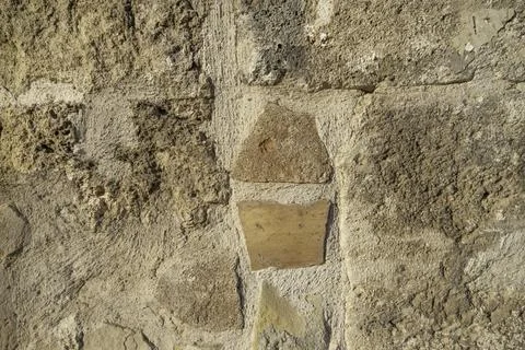 Rough dirty light wall surface of limestone stones and white concrete Stock Photos
