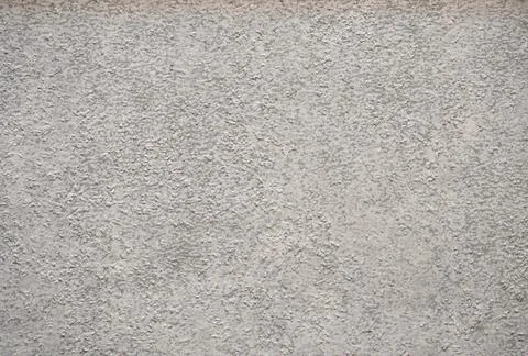 A rough-finished surface of a light gray natural stone with close-up traces o Foto stock