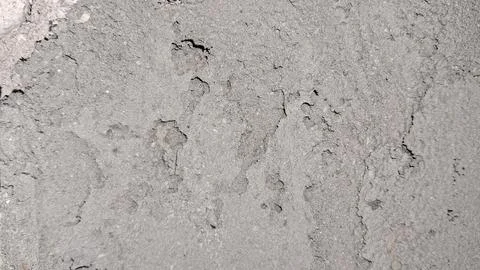 Rough gray concrete texture with deep cracks and weathered surface Stock Photos
