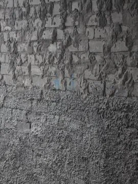 Rough grey cement plaster texture on a brick wall. Stock-Fotos