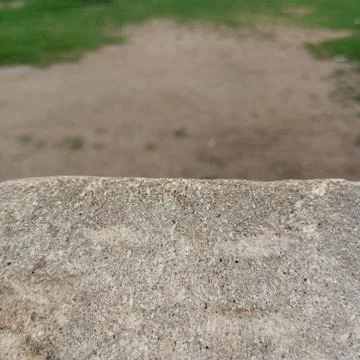 Rough grey concrete stone ledge edge sharply in focus dirt ground Fotos de archivo