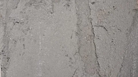 Rough grey concrete wall surface with deep vertical structural cracks Stock Photos