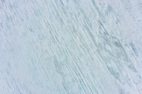 Rough ice texture with diagonal wind streaks aerial top view winter background Stock Photos