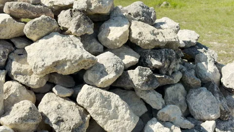 Rough Limestone Wall Rests Securely on a Grassy Meadow in the Bright Sun Stock Footage 334122203