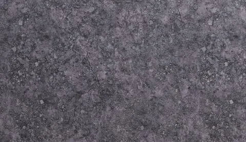 A rough, mottled dark gray surface with numerous small, light-colored parti.. Stock Photos