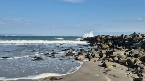 Rough ocean waves crashing on the rocks and sand, big splash in the air Video stock 302094604