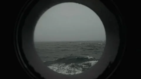 Rough ocean waves through a ship porthole close up Stock-Footage 347823939