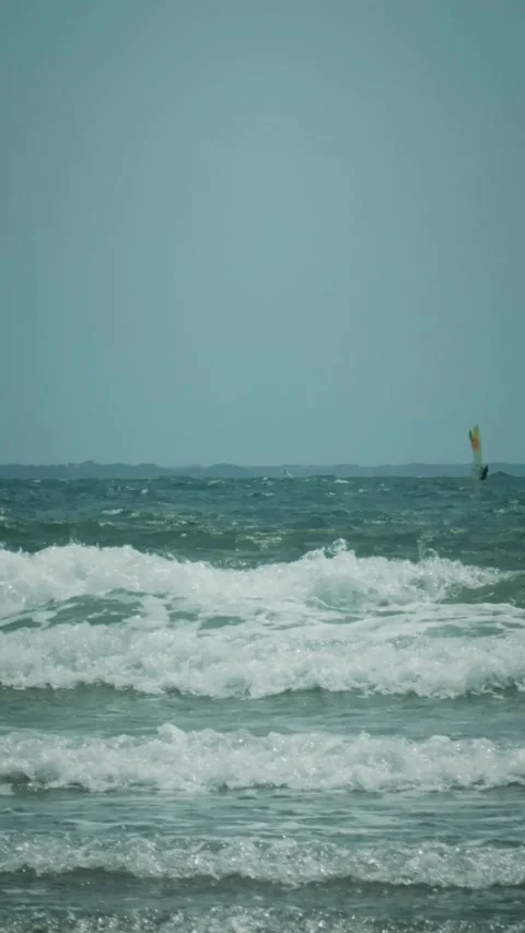 Rough ocean waves with whitecaps and distant windsurfers Stock Footage 346275167