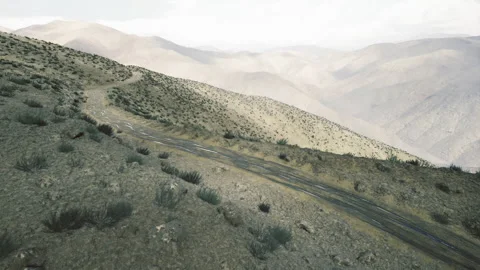 Rough offroad trail weaving through craggy mountain slopes for explorers Stock Footage 342431546