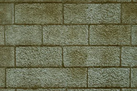 Rough old stone block wall. Green background. Stock Photos