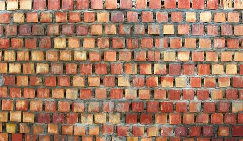 A rough orange brick wall recently made with fresh wet cement Stock Photos