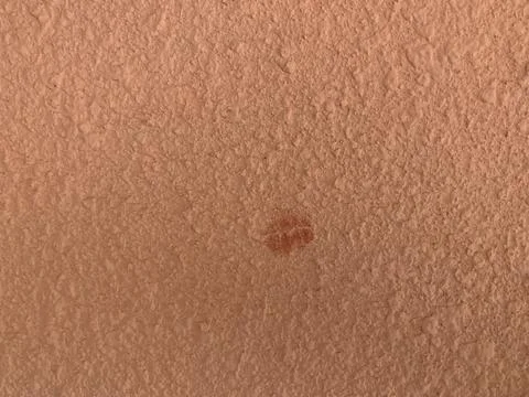 Rough Peach Wall Texture with Faint Red Circular Stain Stock Photos