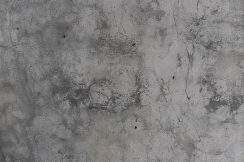 Rough plaster wall of the building with cracks and stains of dirty gray. Fotos de archivo